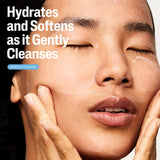 Woman applying skincare product with text 'Hydrates and Softens as it Gently Cleanses' on a white background