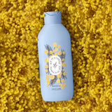 Blue bottle of shower gel with a floral design on a yellow floral background