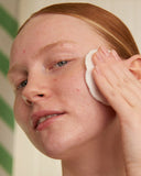Person cleaning their face with a white cloth